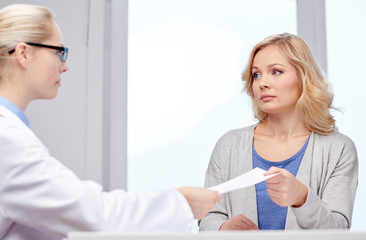 Obraz premium doctor giving prescription to woman at hospital