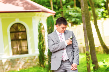 Portrait of the groom in a park on their wedding day.