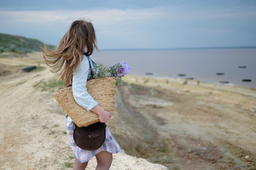 Young Caucasian woman walking along a beach