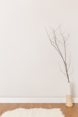 Lonely little twig in vase on white background