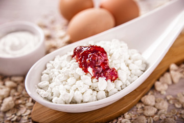 Fototapeta na wymiar Cottage cheese with jam, eggs on the background of scattered muesli.