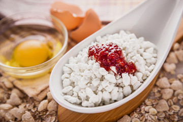 Fototapeta na wymiar Cottage cheese with jam, eggs on the background of scattered muesli.