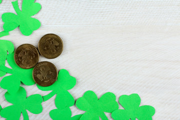 Green Shamrocks clovers on wooden background with Golden coins. Background for St. Patrick's Day celebration