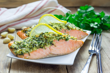Baked salmon with macadamia-cilantro crust on a white plate