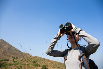 Woman use of the binocular when going hiking