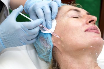 Naklejka premium Cosmetic treatment with injection in a clinic