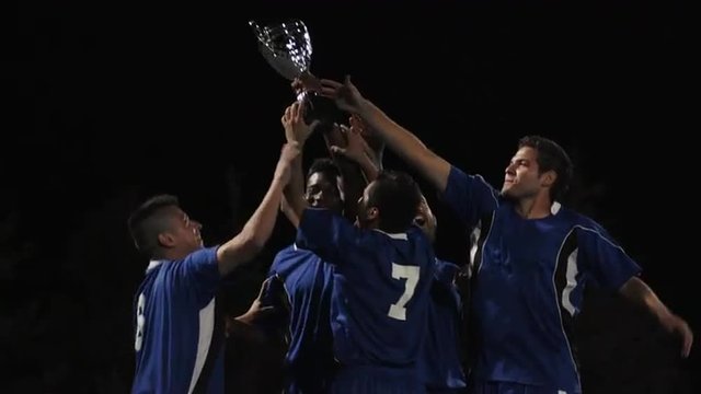 A trophy being held up high by a team