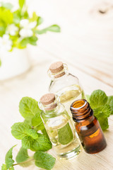 fresh mint essential oil on wooden board