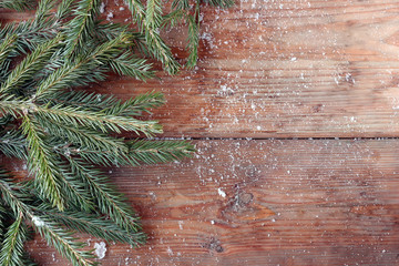 Winter background with fir-tree branches on boards.