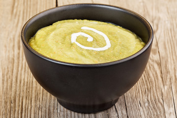 vegetable mash in black bowl on wooden table