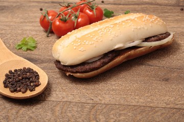  baguette with meat cutlets with onion and a spoon with pepper