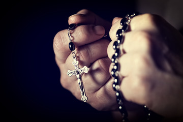  Caucasian person's hands tighten a Christian rosary for prayer. concept of religious belief and faith. - obrazy, fototapety, plakaty