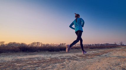 ragazza atletica si allena all'aperto su terra di sera
