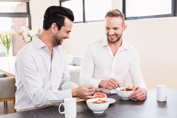 Smiling gay couple having breakfast
