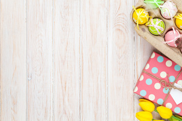 Easter background with yellow tulips and colorful eggs