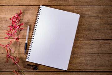 Blank Notebook with Flower on Wooden Table