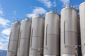 Giant industrial tanks on the bright blue sky