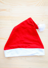 Obraz na płótnie Canvas Christmas hat on bright wooden background