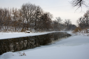 Winter landscape with frozen river , snow and sun