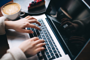 Close up young woman hands typing on laptop