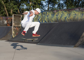 Skateboarder doing a jumping trick at skateboard park