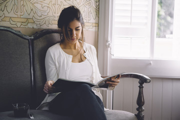 woman sitting reading a magazine