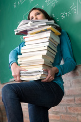 student holding a lot of books