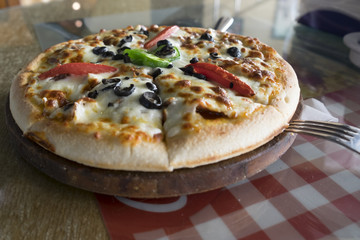 Fresh pizza put on table inside restaurant 