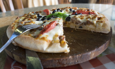 Fresh pizza put on table inside restaurant 