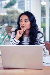 Fototapeta premium Attractive Asian woman using laptop with hand on chin
