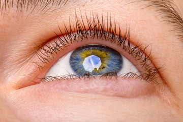 Closeup shot of woman eye - looking up. Human blue eye with reflection. Macro shot. 