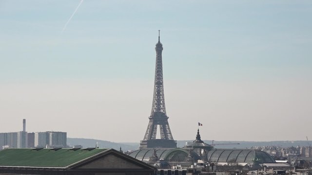 Eiffel Tower with roofs of Paris, tilt - 60fps. Eiffel Tower and Grand Palais des Champs-Élysées view from a high angle. Tilt down. 1080p