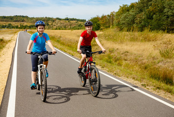 Obraz premium Healthy lifestyle - teenage girl and boy cycling 