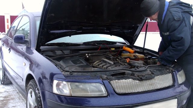 Mechanic using an electronic tester on a car engine