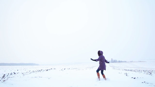 Beautiful girl playing in the snow field