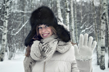 Portrait of a beautiful young woman walking under snowfall