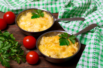 French cuisine. Сhicken with mushrooms baked with cheese in a cocotte