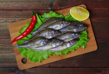 raw redfish ruff fish on the kitchen table with vegetables and lemon