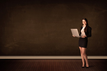 Businesswoman holding high tech laptop on background with copysp