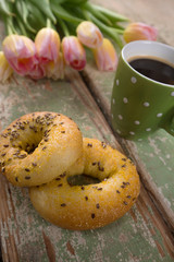 High angle view of breakfast, cup of coffee and bouquet of tulips on wooden table