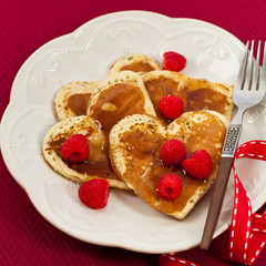 Heart shaped pancakes with raspberry. Selective focus.