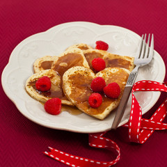 Heart shaped pancakes with raspberry. Selective focus.