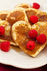 Heart shaped pancakes with raspberry. Selective focus.