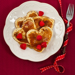 Heart shaped pancakes with raspberry. Selective focus.