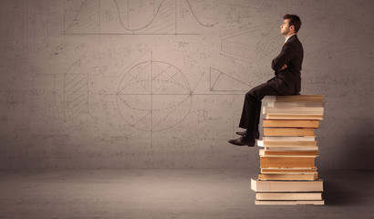 Businessman sitting on books