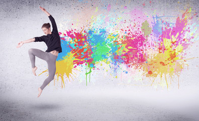 Naklejka na ściany i meble Modern street dancer jumping with colorful paint splashes