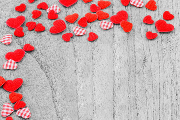 Small red hearts putting on monochrome wooden background