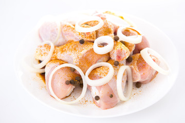 raw chicken drumsticks on white background