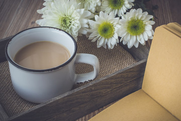 coffee with flowers on tray and blank book in vintage tone