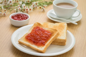 Toast with jam on plate and coffee cup